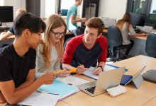 A photo of three high school students collaborating on a project in a maker space.