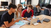 A photo of three high school students collaborating on a project in a maker space.