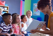 Teacher reading picture book to group of students