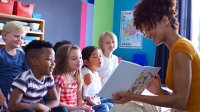 Teacher reading picture book to group of students