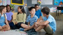 Elementary students sitting and talking on the floor