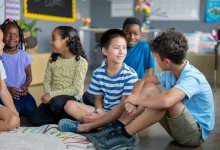Elementary students sitting and talking on the floor