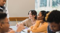 A photo of high schoolers discussing in small groups.