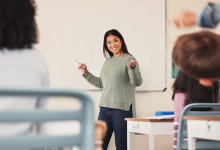 Young teacher standing at whiteboard in front of the class