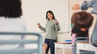 Young teacher standing at whiteboard in front of the class