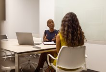 Two adults talking in a conference room