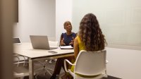 Two adults talking in a conference room