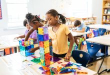 Elementary students building towers with magnetic tiles