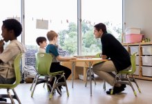 Elementary teacher talking to two students