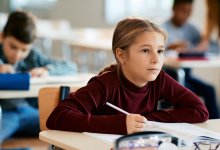 Elementary student taking notes at desk