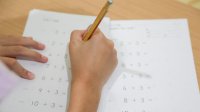 Elementary student completing math worksheet