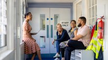 A photo of a group of teachers having a discussion in a school hallway.
