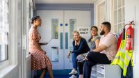 A photo of a group of teachers having a discussion in a school hallway.