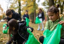 A photo of elementary students outdoors picking up trash.