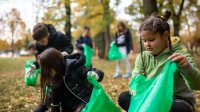 A photo of elementary students outdoors picking up trash.