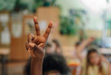 Student holding up two fingers in class