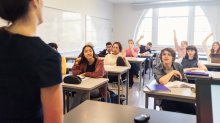 A photo of a middle school teacher lecturing to an engaged classroom.