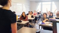 A photo of a middle school teacher lecturing to an engaged classroom.