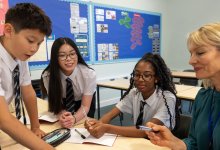 A photo of a teacher working with a small group of middle school students.
