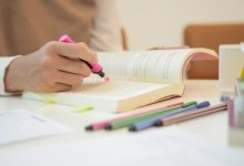 Person highlighting text in a book