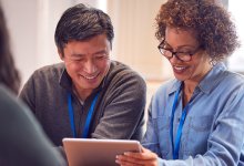 Two teachers collaborating and learning together using the same tablet.