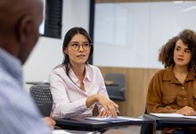 A photo of a group of administrators sitting in a circle and engaging in a discussion.