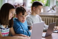 A photo of a classroom of engaged students working on their laptops during class.