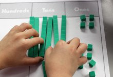 Elementary student working with math place value blocks as part of the CPA method for math