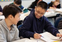 A photo of two elementary students having a discussion about their math worksheet.