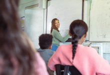 A photo of a teacher guiding middle school students through a math lesson using the whiteboard.