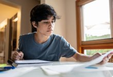 High school student working on homework at his kitchen table