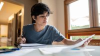 High school student working on homework at his kitchen table