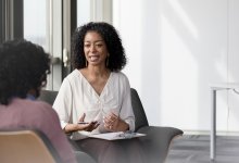 Two coworkers talking in a meeting