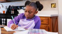 Elementary student doing homework at the kitchen table