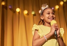Elementary student on stage with a microphone