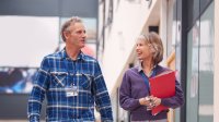 A photo of two teachers doing a learning walk around a school.