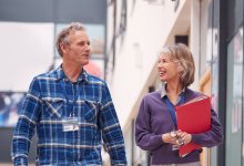 A photo of two teachers doing a learning walk around a school.