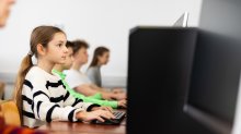 A photo of an elementary classroom in a computer lab taking a standardized test.