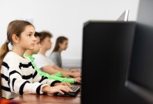 A photo of an elementary classroom in a computer lab taking a standardized test.