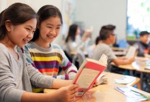 Two middle school students reading books in class, representing a productive classroom before winter break