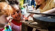 A photo of two preschool students outside excitedly looking at a spider.