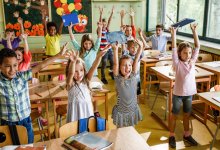 A photo of elementary students stretching in the classroom.