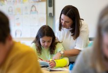 teacher assisting child with broken arm