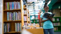 Middle school students reading a picture book in a library