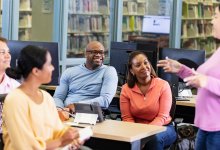 A photo a staff meeting being led with positive energy.