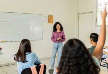 Teacher instructing class while student raises a hand differentiated instruction middle school