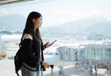 A photo of a high school student waiting for her flight at an airport gate.