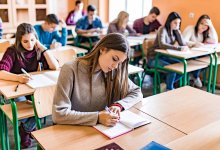 High school students reading and taking notes in class