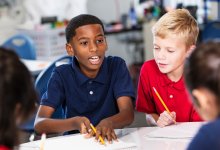 A small group of elementary students working together to a solve a math problem.