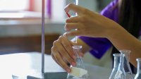 A photo of a high school student performing a titration.